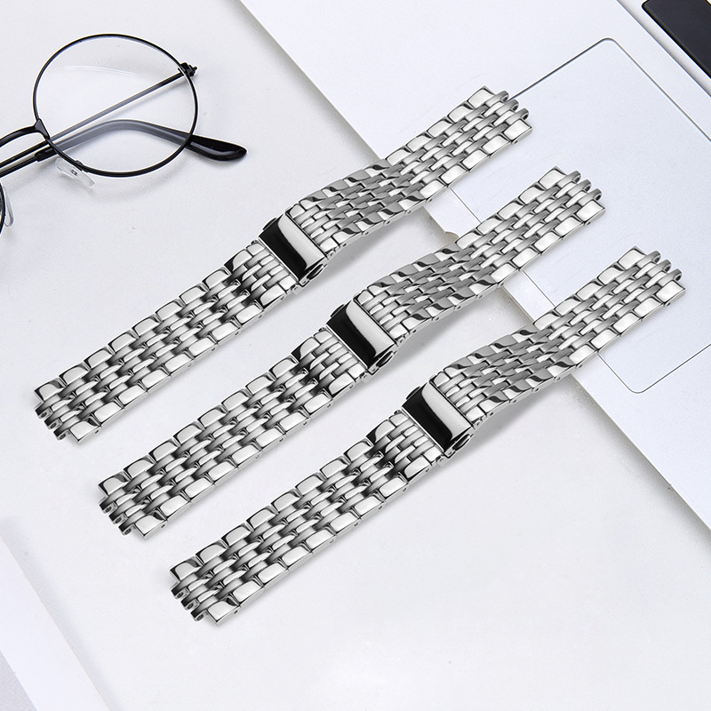 Three multi-row steel bracelets shown on a desk